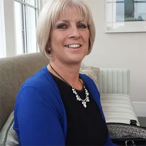 A woman sitting on a couch in a living room.