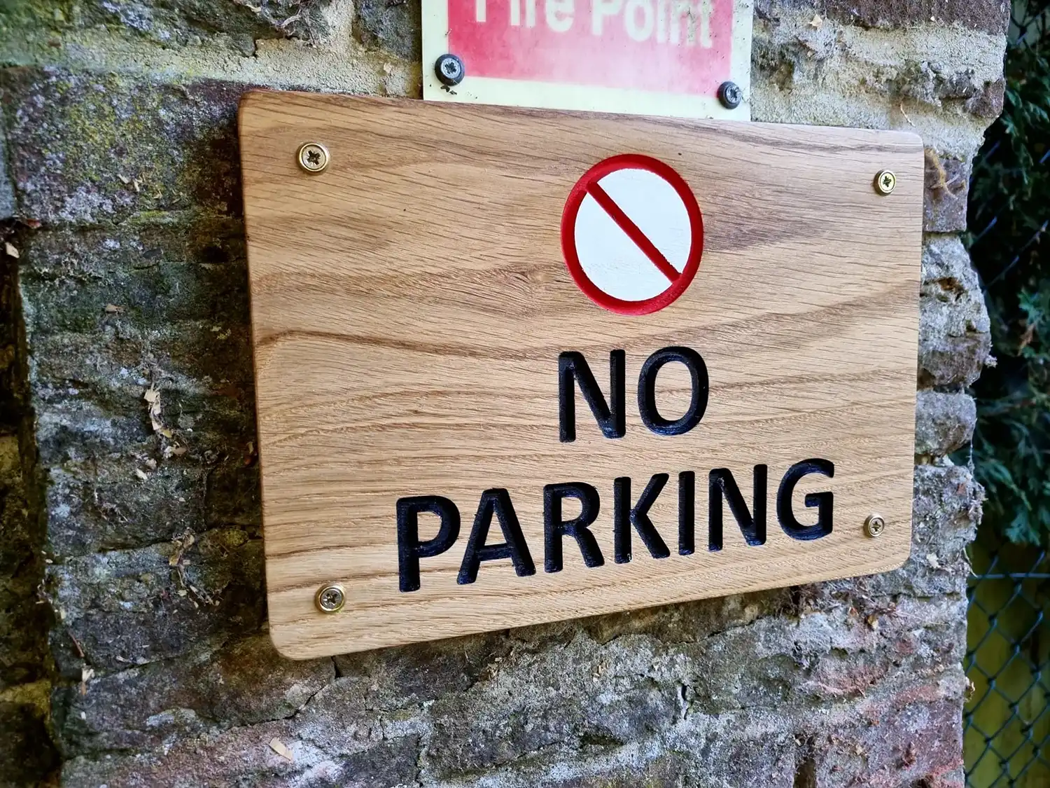a sign that says no parking on the brick wall