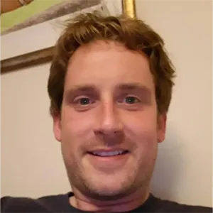 A man with blonde hair is smiling for the camera.