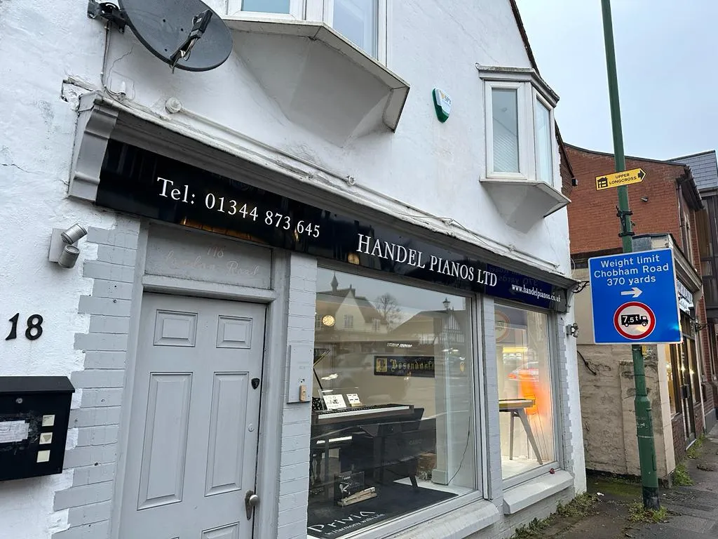 a white building with a new sign on the front of it